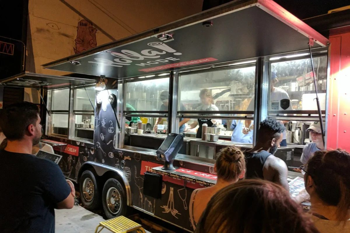 Customers lining up at a colorful street food truck, showing how to find the best local food trucks