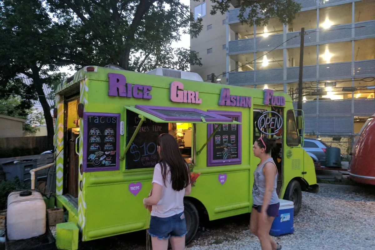 Customers lining up at a colorful truck at night, one of the best Miami food trucks by neighborhood