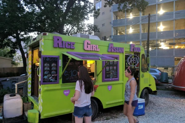 Customers lining up at a colorful truck at night, one of the best Miami food trucks by neighborhood